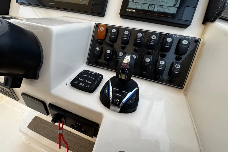 Slide: The Image of Control panel of 2022 Grady-White Freedom 285 boat with switches and joystick. - 30