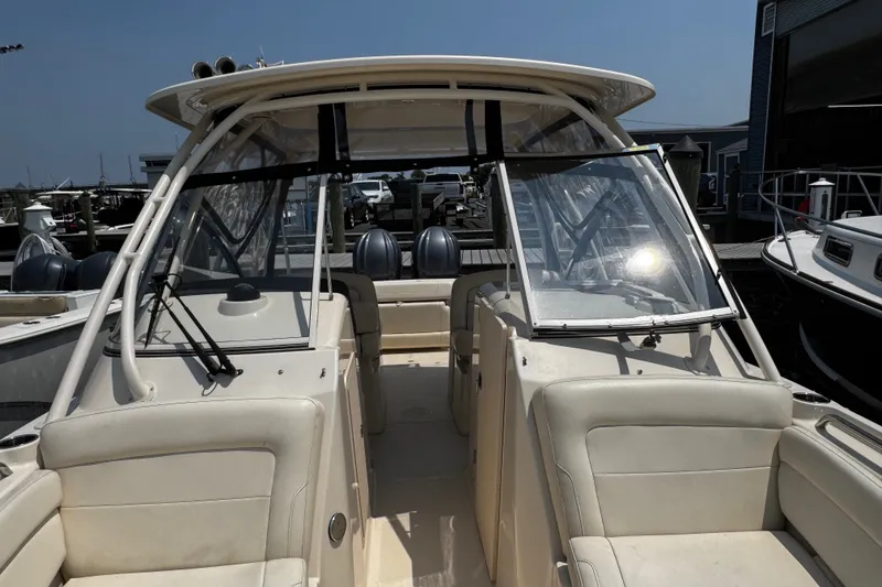Slide: The Image of 2022 Grady-White Freedom 285 boat interior with dual consoles and seating at a marina. - 14