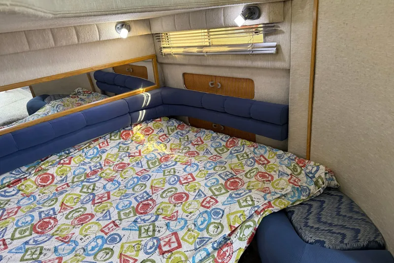 Slide: The Image of Cozy cabin interior of 1990 Sea Ray 420 Sundancer with colorful bedding and blue cushions. - 25
