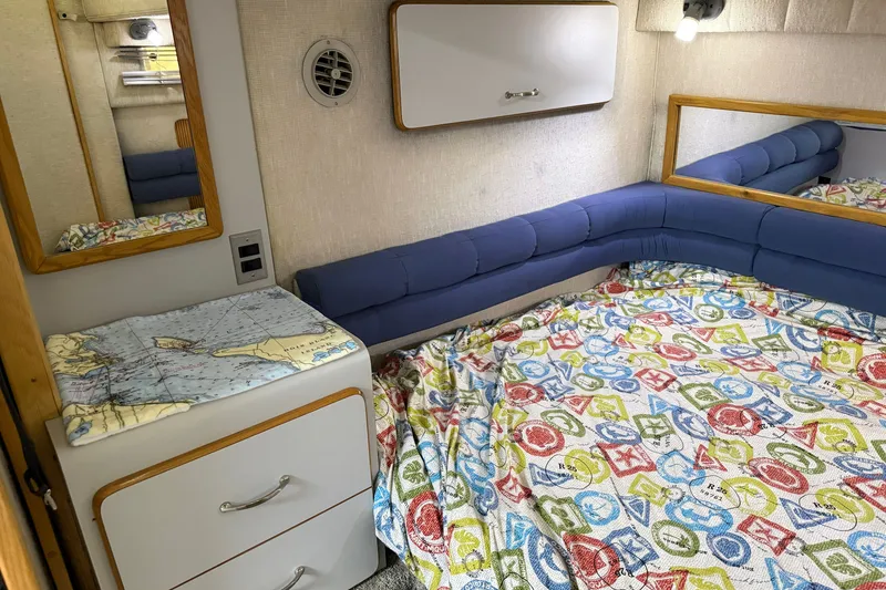 Slide: The Image of Interior of 1990 Sea Ray 420 Sundancer with colorful bedding and nautical decor. - 26
