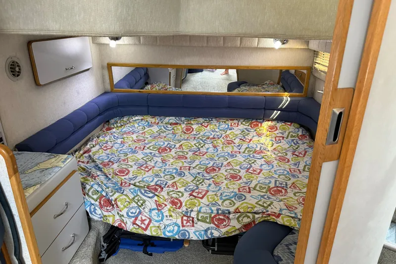 Slide: The Image of Interior cabin of 1990 Sea Ray 420 Sundancer with colorful bedding and blue seating. - 24