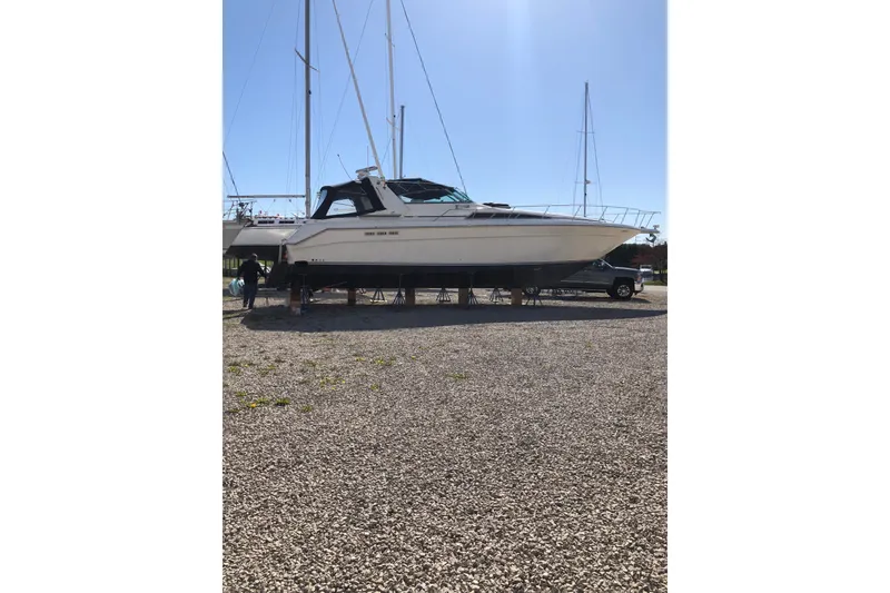 Slide: The Image of 1990 Sea Ray 420 Sundancer yacht on dry dock under clear blue sky. - 34
