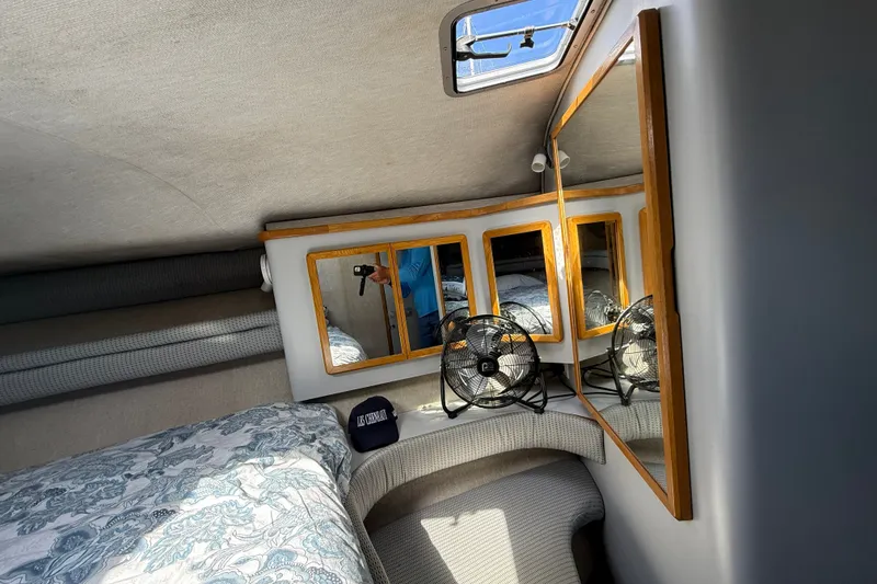 Slide: The Image of Interior of 1990 Sea Ray 420 Sundancer with mirrors, bed, and fan. - 22