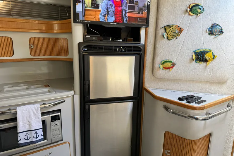 Slide: The Image of Interior of 1990 Sea Ray 420 Sundancer with kitchen appliances and decorative fish art. - 15