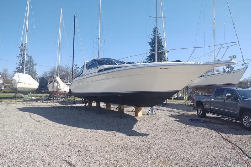 Slide: The Image of 1990 Sea Ray 420 Sundancer yacht on dry dock, surrounded by other boats and a truck. - 35