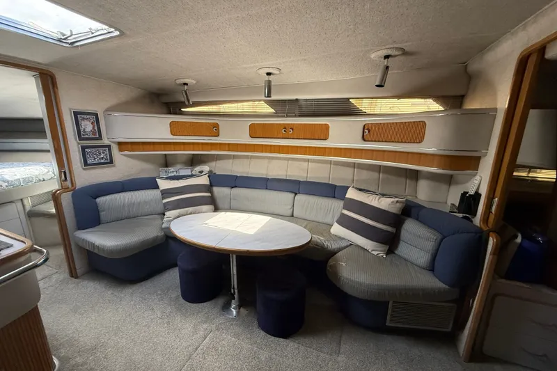 Slide: The Image of Interior of 1990 Sea Ray 420 Sundancer yacht with cozy seating and table. - 16