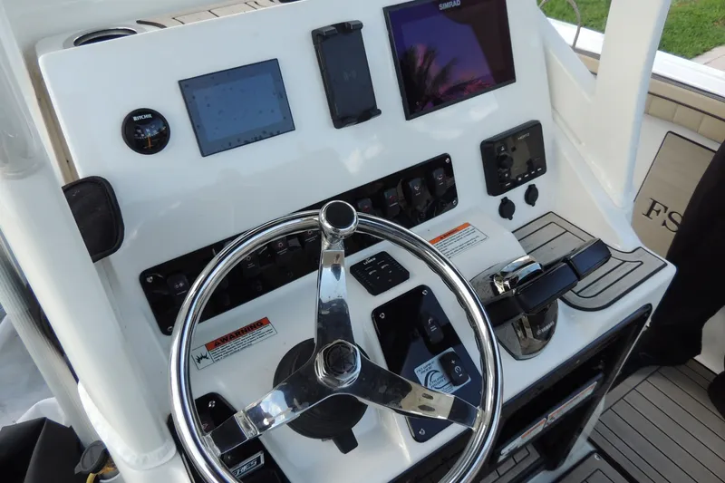 Slide: The Image of 2023 Yamaha Boats 222 FSH Sport E dashboard with steering wheel and electronic controls. - 5