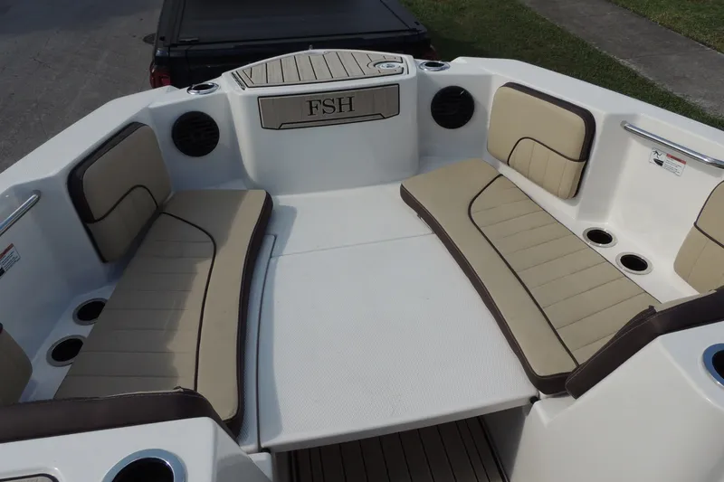 Slide: The Image of 2023 Yamaha Boats 222 FSH Sport E interior with beige seating and cup holders. - 20
