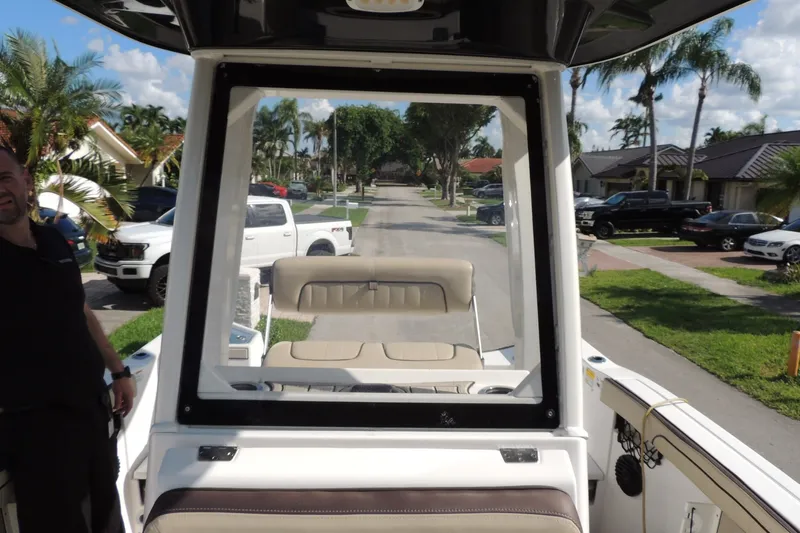 Slide: The Image of 2023 Yamaha Boats 222 FSH Sport E on a residential street with palm trees. - 17