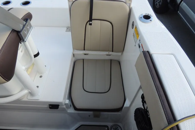 Slide: The Image of 2023 Yamaha Boats 222 FSH Sport E interior seating with beige and brown upholstery. - 12