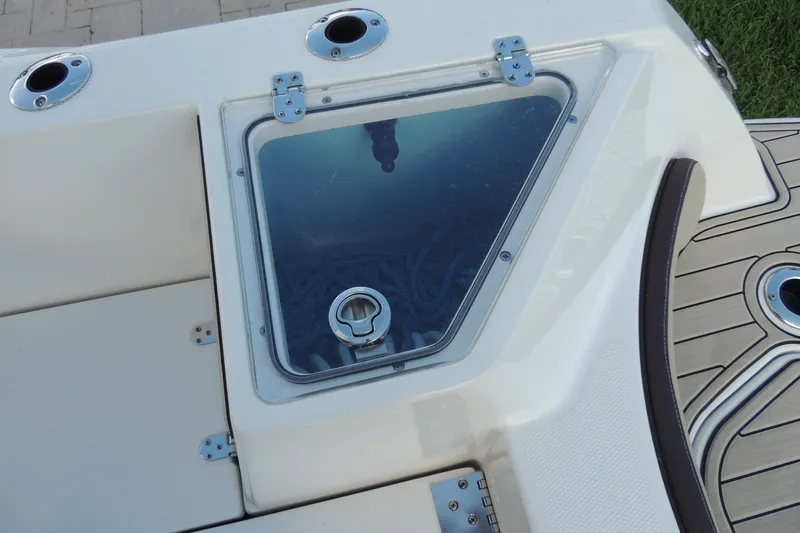 Slide: The Image of 2023 Yamaha Boats 222 FSH Sport E deck with storage compartment and rod holders. - 13