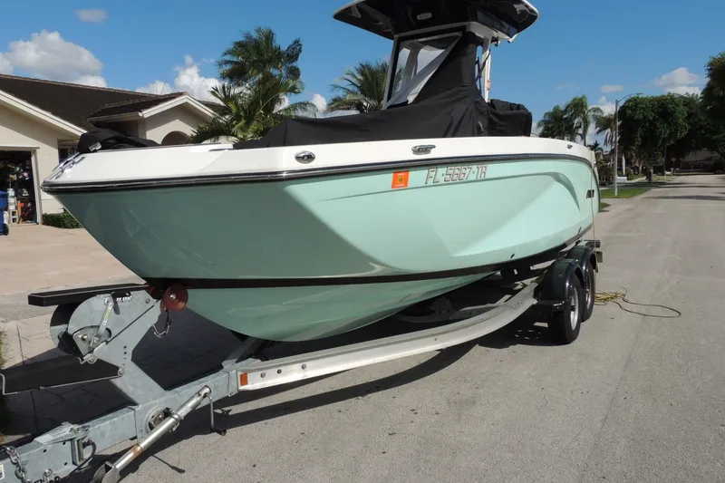 The Image of 2023 Yamaha Boats 222 FSH Sport E on trailer, parked in residential area. - 0