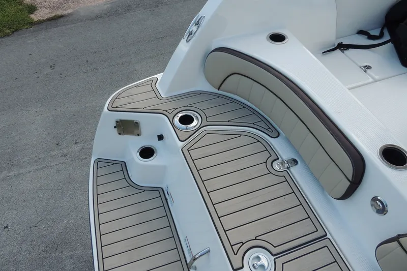Slide: The Image of 2023 Yamaha Boats 222 FSH Sport E swim platform with cushioned seating and cup holders. - 8
