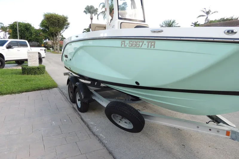 Slide: The Image of 2023 Yamaha Boats 222 FSH Sport E on trailer, parked in driveway. - 3