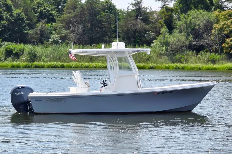 The Image of 2024 Parker 2300 Special Edition boat on a serene lake with lush greenery. - 1
