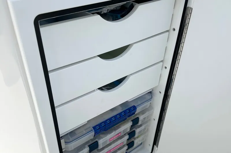 Slide: The Image of Storage compartment with organized drawers in a 2024 Parker 2300 Special Edition boat. - 15