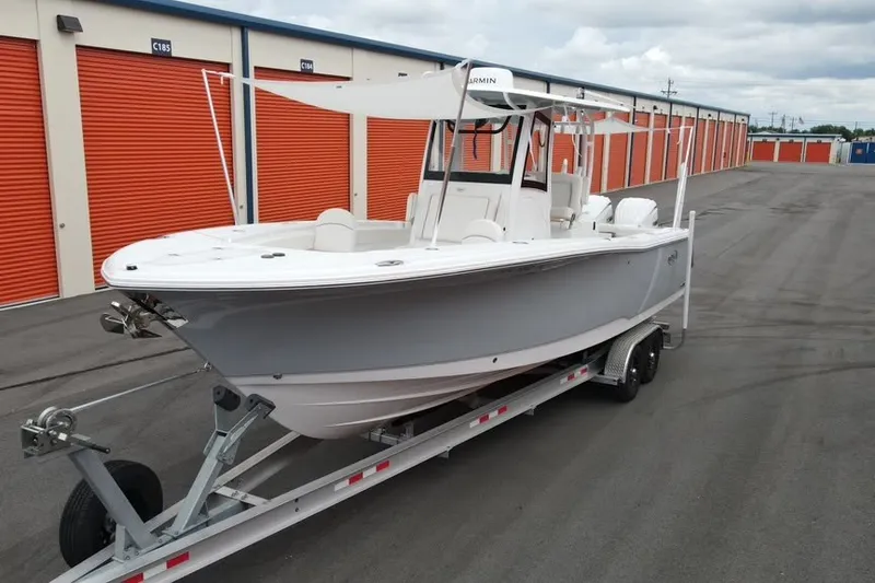 The Image of 2025 Sea Hunt Gamefish 28 boat on trailer, parked near orange storage units. - 0