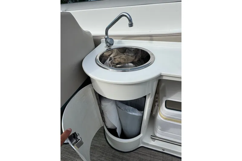 Slide: The Image of Compact sink area on a 1996 Cobalt 272 boat with storage cabinet. - 15