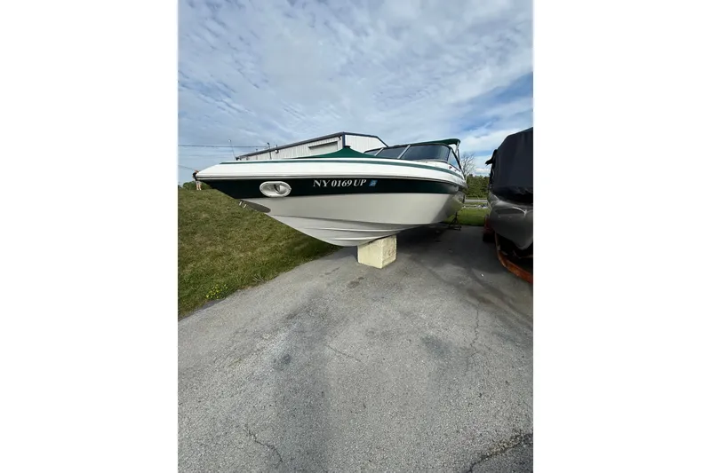 Slide: The Image of 1996 Cobalt 272 boat on a concrete block, parked outdoors under a cloudy sky. - 31