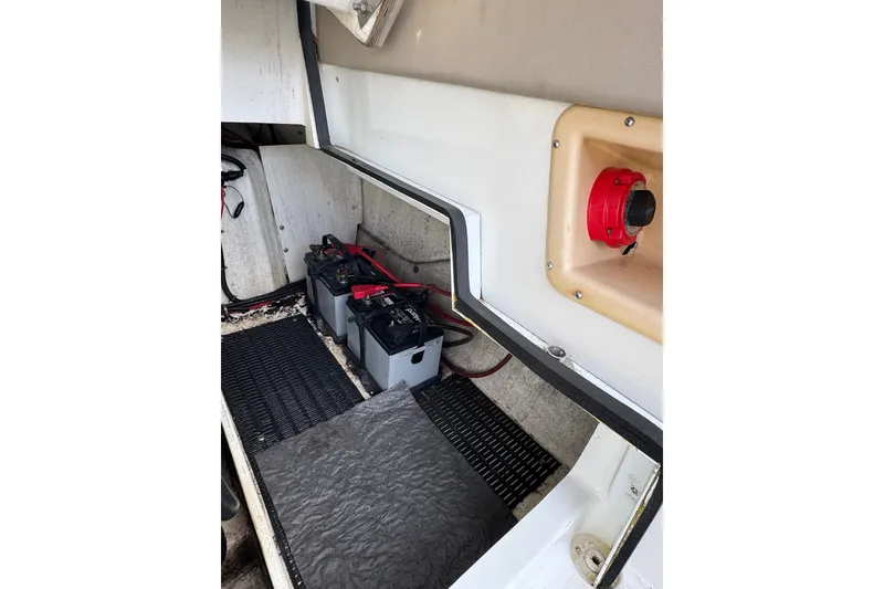 Slide: The Image of Battery compartment of a 1996 Cobalt 272 boat, featuring dual batteries and a red switch. - 54
