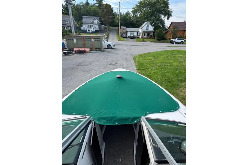 Slide: The Image of 1996 Cobalt 272 boat with green cover, parked in residential area. - 36