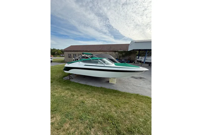 Slide: The Image of 1996 Cobalt 272 boat displayed outdoors on grass under a partly cloudy sky. - 29