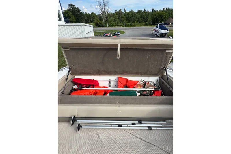 Slide: The Image of Open storage compartment in a 1996 Cobalt 272 boat, containing life jackets and equipment. - 55