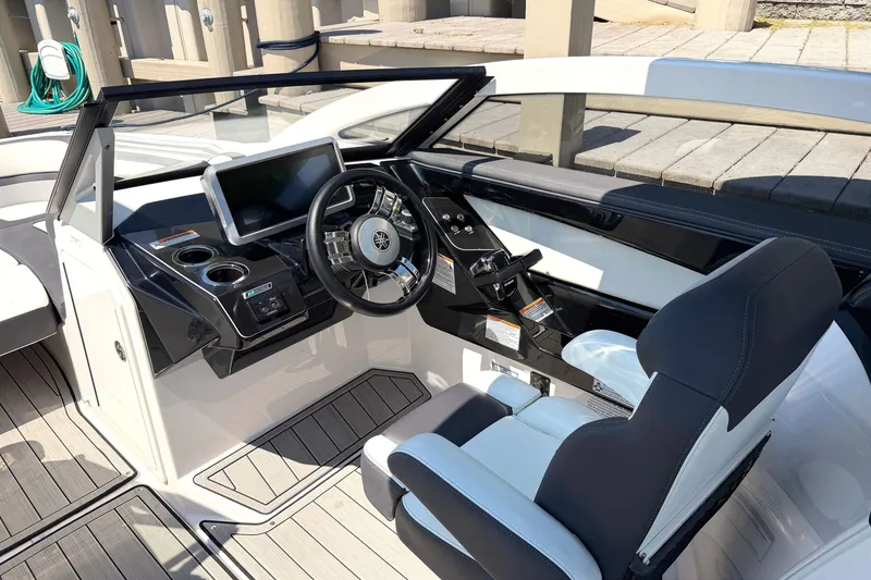 Slide: The Image of 2023 Yamaha Boats 275SE cockpit with modern steering and dashboard controls. - 13