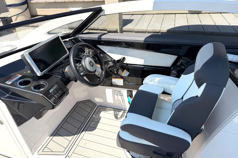 Slide: The Image of 2023 Yamaha Boats 275SE cockpit with steering wheel, touchscreen, and captain's chair. - 12