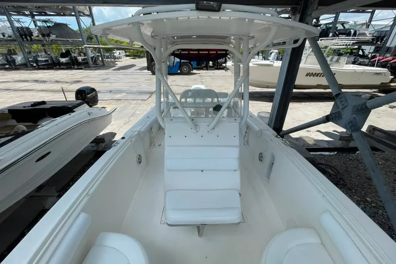 Slide: The Image of 2007 Edgewater 245CC boat interior with white seating and canopy in a marina setting. - 22