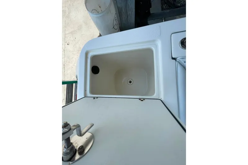 Slide: The Image of Livewell compartment on a 2007 Edgewater 245CC boat, featuring a clean, white interior. - 21