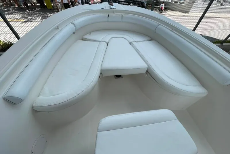 Slide: The Image of 2007 Edgewater 245CC boat interior with white cushioned seating in a spacious layout. - 18