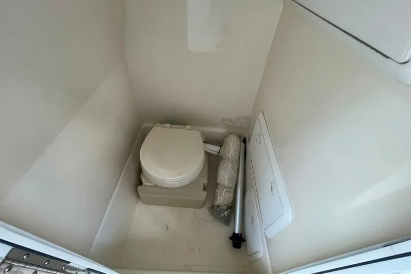 Slide: The Image of Compact marine toilet in 2007 Edgewater 245CC boat cabin, with storage compartments and rope. - 20
