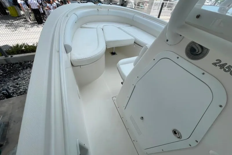 Slide: The Image of 2007 Edgewater 245CC boat interior with white seating and storage compartment. - 17