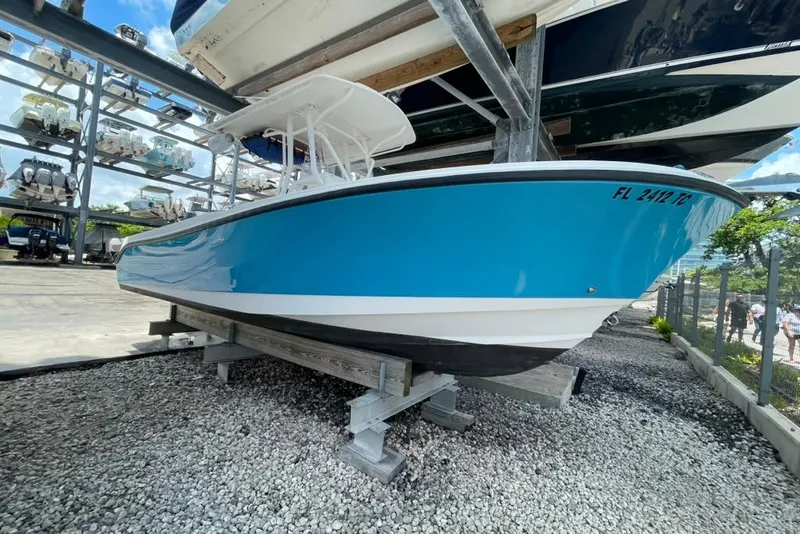 Slide: The Image of 2007 Edgewater 245CC boat in vibrant blue, stored on a rack in a marina. - 24