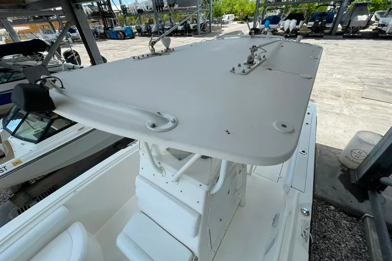 Slide: The Image of 2007 Edgewater 245CC boat with T-top, docked in a marina setting. - 19