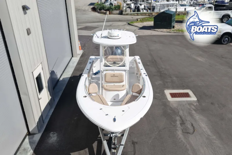 Slide: The Image of 2019 Sportsman Open 232 Center Console boat on trailer, parked near a marina. - 2