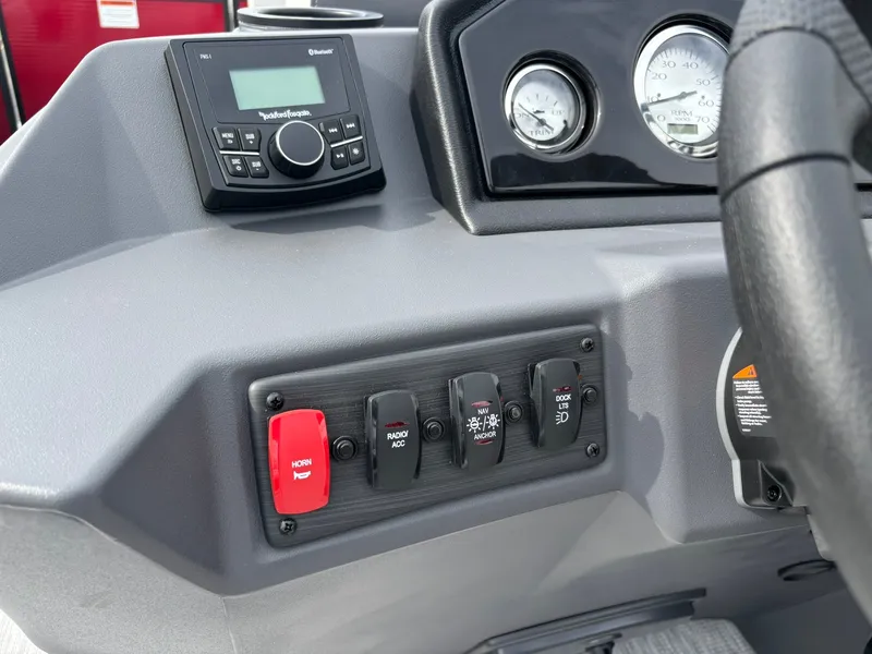 Slide: The Image of The image shows the dashboard of a Bennington 21 S1SB SPS boat with various switches and gauges. - 21