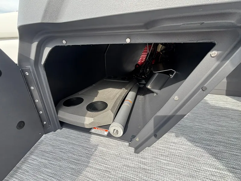 Slide: The Image of A storage compartment inside a boat with cup holders and a gray surface. - 18