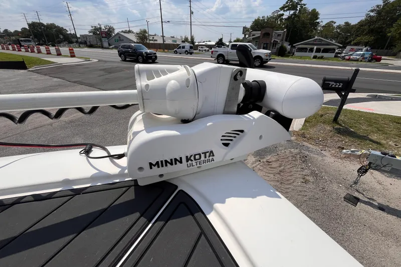 Slide: The Image of Minn Kota Ulterra motor on 2022 Tidewater 2500 Carolina Bay boat, parked near a busy road. - 12