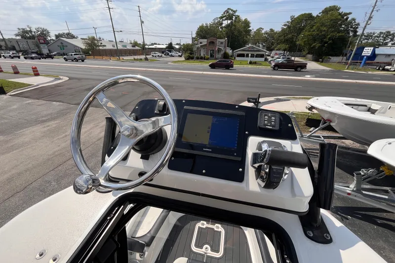 Slide: The Image of 2022 Tidewater 2500 Carolina Bay boat dashboard with steering wheel and navigation display. - 18