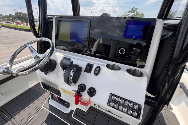 Slide: The Image of Control panel of 2022 Tidewater 2500 Carolina Bay boat with steering wheel and navigation screens. - 8