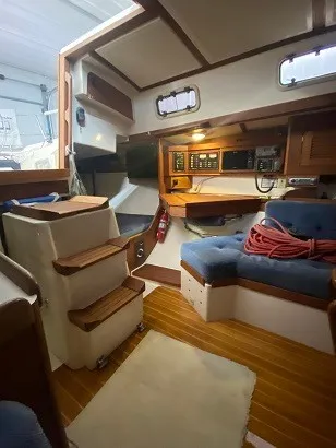 Slide: The Image of Interior of a 1992 Tartan 3100 with wooden floors, blue upholstery, and navigation equipment. - 5