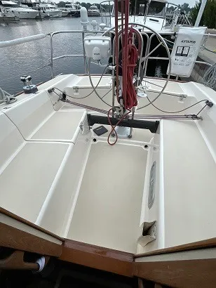 Slide: The Image of The cockpit of a 1992 Tartan 3100 with a steering wheel and navigation equipment. - 4