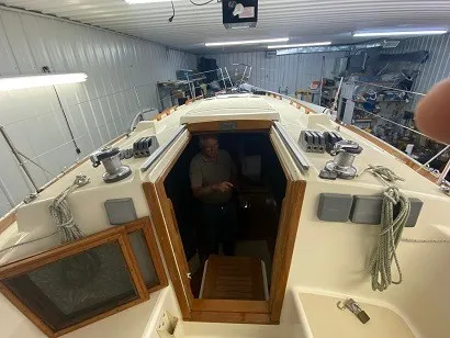 Slide: The Image of A man stands inside a 1992 Tartan 3100, which is situated in a warehouse. - 3