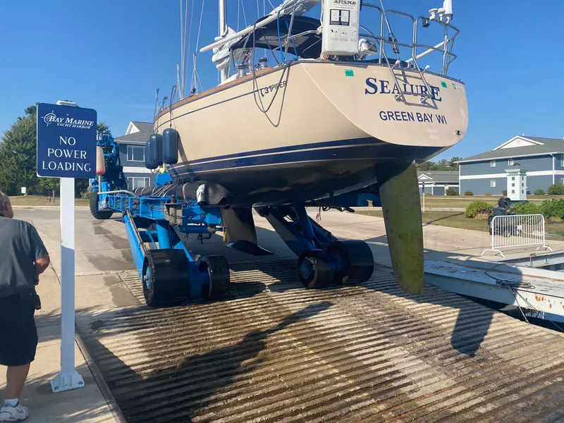 Slide: The Image of A 1992 Tartan 3100 is being pulled out of the water on a blue trailer. - 1