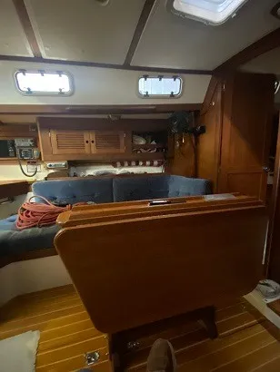 Slide: The Image of Interior of a 1992 Tartan 3100 with wooden furnishings and blue upholstery. - 8