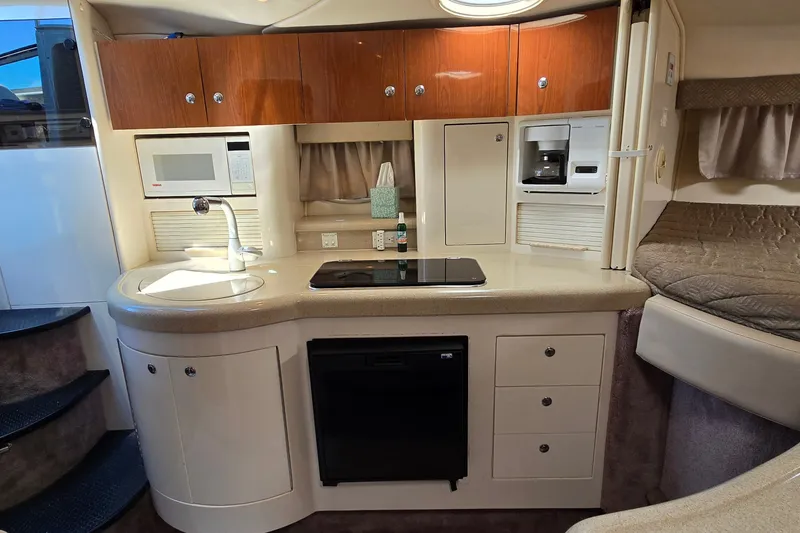 Slide: The Image of Interior of a 2001 Monterey 322 Cruiser featuring a compact kitchen with modern amenities. - 22