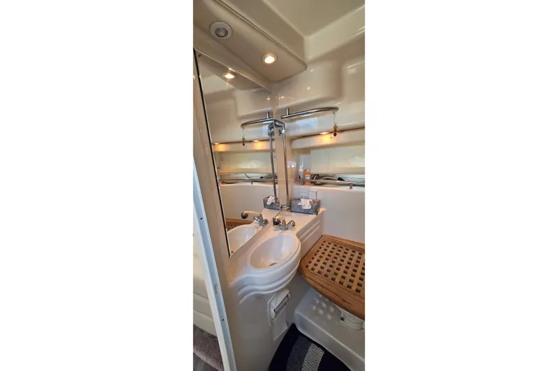Slide: The Image of Bathroom interior of 2001 Monterey 322 Cruiser with sink, mirror, and wooden seat. - 28