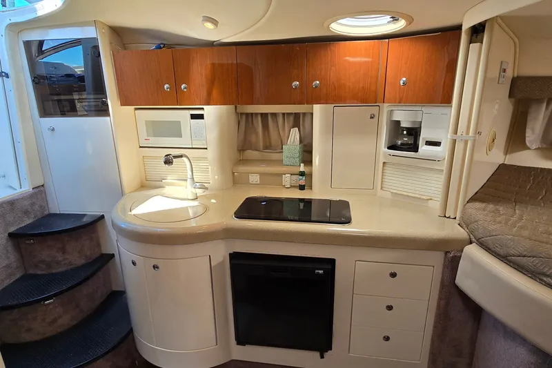 Slide: The Image of 2001 Monterey 322 Cruiser kitchen with microwave, stove, and cabinets in a compact layout. - 20